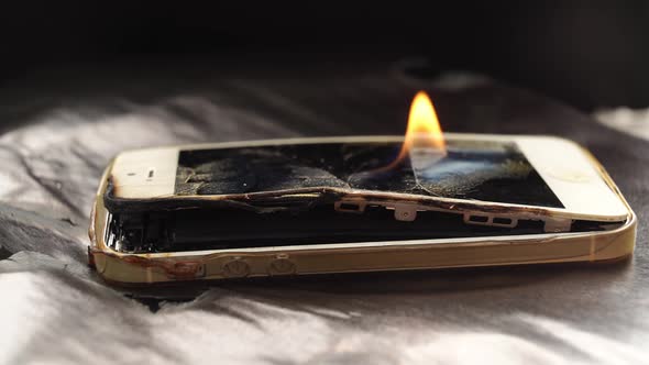 Burning Broken Smartphone on a Black Background