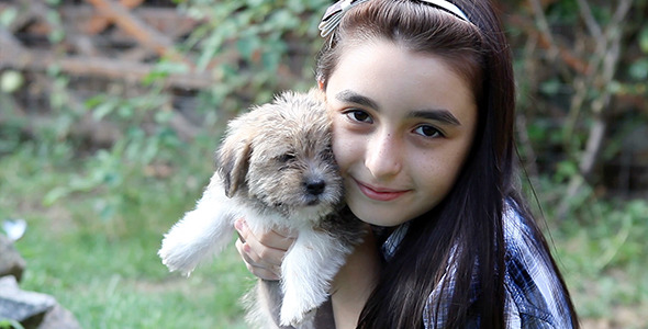 Girl Cuddling a Puppy Outdoors