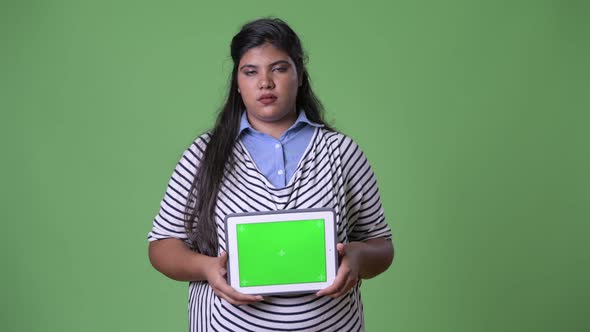 Young Overweight Beautiful Indian Businesswoman Against Green Background