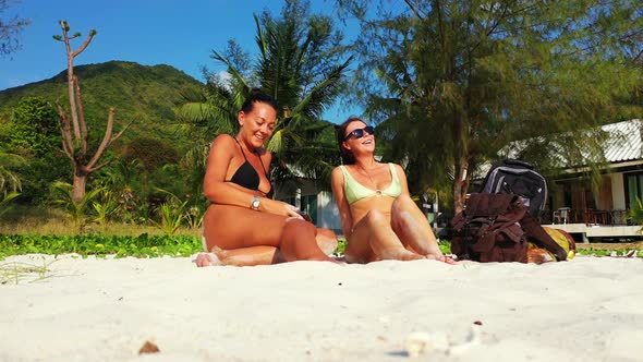 Pretty fun women on vacation having fun at the beach on summer white sand and blue  background