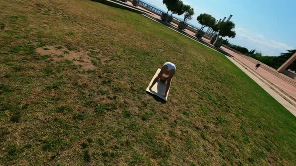 Girl in White Dress Doing Stretching Exercises on the Grass at Sunny Day