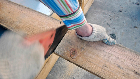 Sawing The Plank With A Hand Saw