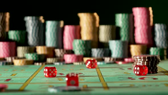 Red Dice Falling on a Gaming Table in a Casino on a Black Background with Blurry Chips