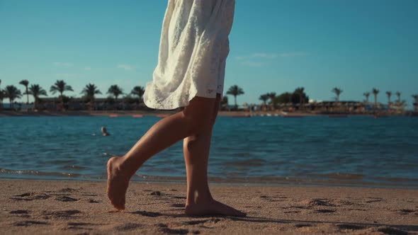 Barefoot Unrecognizable Girl Leaving Footprints on Sand of Seashore