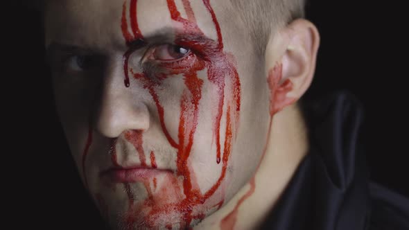 Halloween Man Portrait. Guy with Dripping Blood on His Face. Scary Makeup