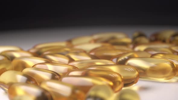 Close Up Footage of Yellow Transparent Pills That Lie on a Spinning White Table. Antiviral Pills