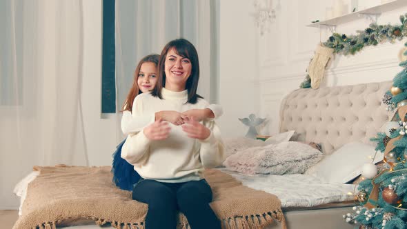 Happy Mother with Her Daughter in the Room Together on Christmas Night