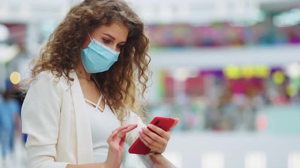 Woman in Mask Checking Social Media at Store