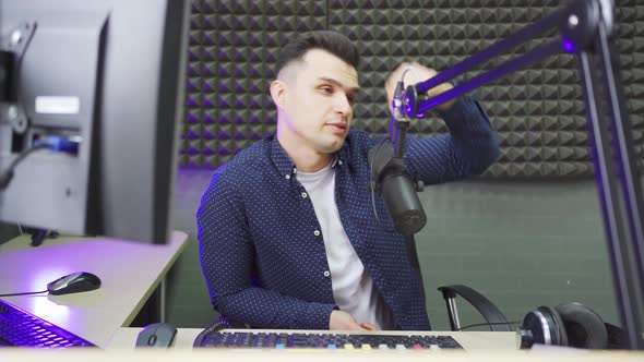a Male Radio Host Conducts a Live Broadcast in a Professional Radio Studio