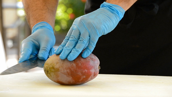 Chef Hands Cutting a Mango Fruit