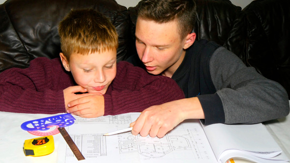 Teen Explaining Architectural Plan To His Brother alt