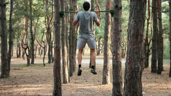 Man Doing Pull-ups In The Forest