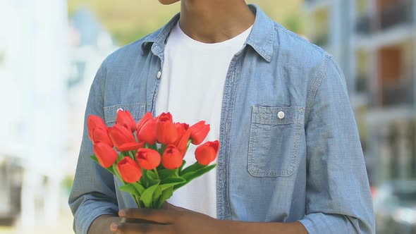 Worried Boy Holding Flowers, Looking Out For Girlfriend