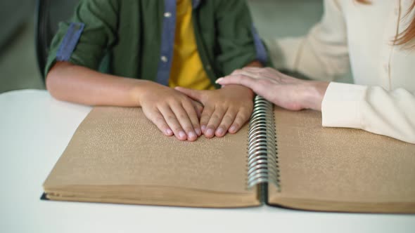 Blind Child Boy Read Book Closeup of the Fingers of Kid Touching to Braille Code Mom Supports and