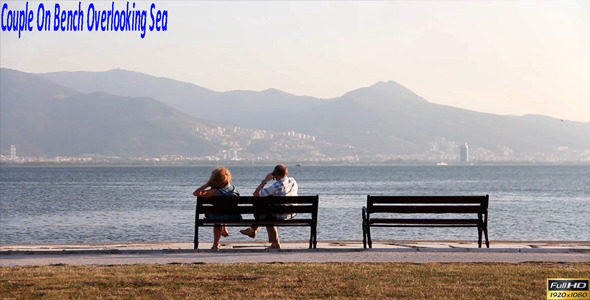 Couple On Bench Overlooking Sea