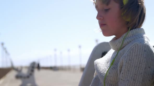 Girl listening music on headphones at beach 