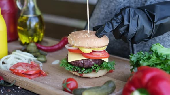 Making Burger  Putting Skewer to a Freshly Made Hambnurger Sandwich