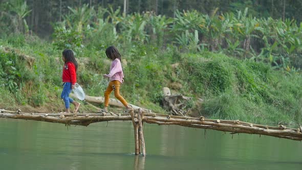 Rural Kids Walking On Wooden Bridge Through The River