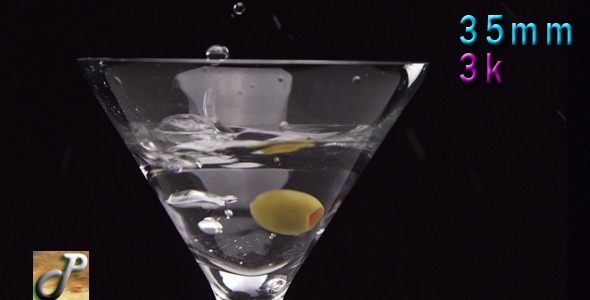 Martini Cocktail With Olive Falling In The Glass