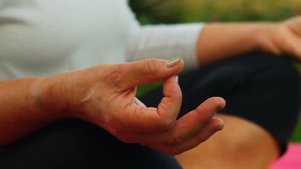 Senior woman performing yoga in garden 4k