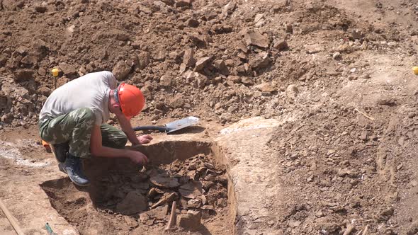 Young Archeologist Works on an Archaeological Site at Morning Sun Rays at Summer Heat