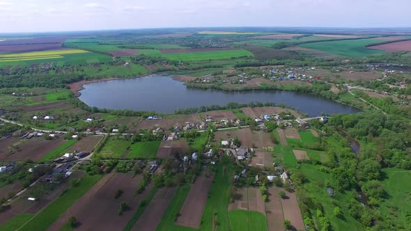 Village by the pond. Aerial view of small village houses near pond water