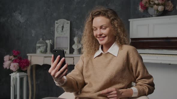 Young Caucasian Woman on a Video Call Using Her Smart Phone Indoors