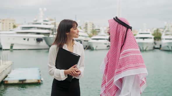 Arab Businessmen Discussing Contract Terms and Deal Details with Yacht Broker Before Closing Deal