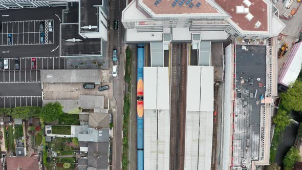 Top down Drone shot over South Western British Rail train leaving Twickenham station