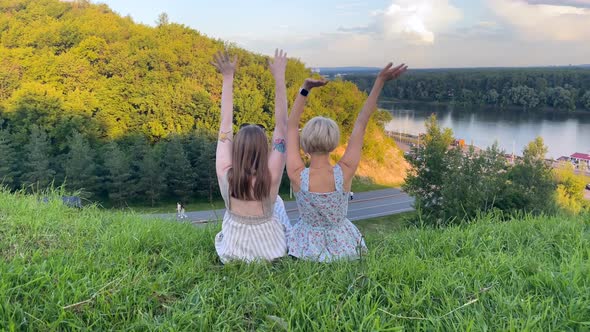 Two Girls Raise Their Hands Up and Wave