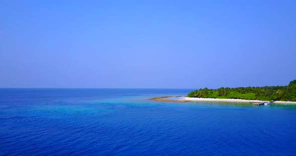 Beautiful flying tourism shot of a white sandy paradise beach and aqua blue ocean background