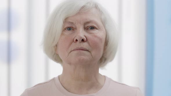 Crop View of Mature Woman with White Hair Raising Head and Looking to Camera