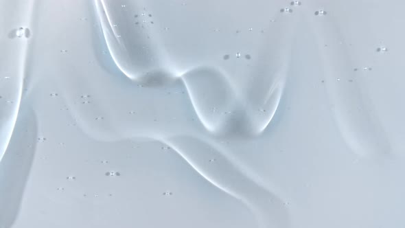 Transparent Cosmetic Gel Fluid Flowing Down on a White Surface