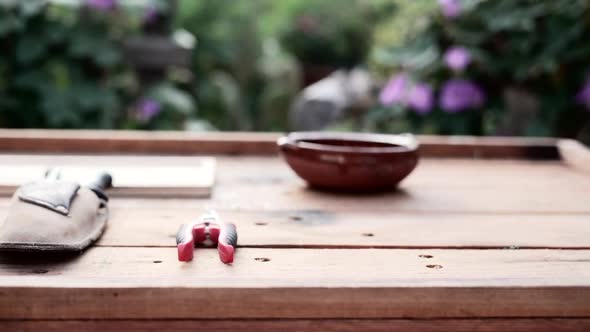 Tools for Marijuana Farming Displayed on Wooden Table in Front of Garden