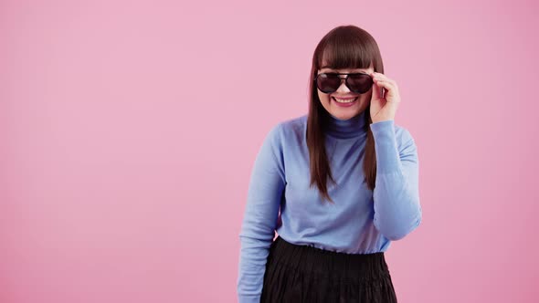 Funky Caucasian Brunette with Bangs Slowly Takes Off Her Sunglasses and Laughs to the Camera Over