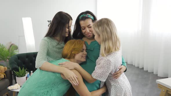 Young Beautiful Caucasian Women Hugging and Smiling. Happy Girls Embracing Their Pregnant Friend