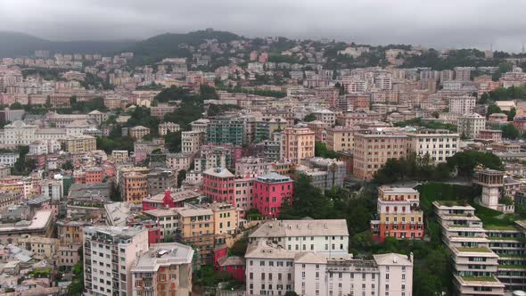 Vibrant cityscape of Genoa city on cloudy day, aerial cinematic view