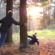 A Teenager Plays with a Child Runs in the Park Around a Tree and Catches Up with Him - VideoHive Item for Sale