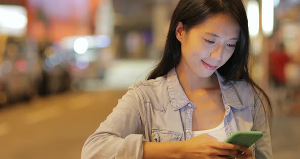 Woman using cellphone at night 