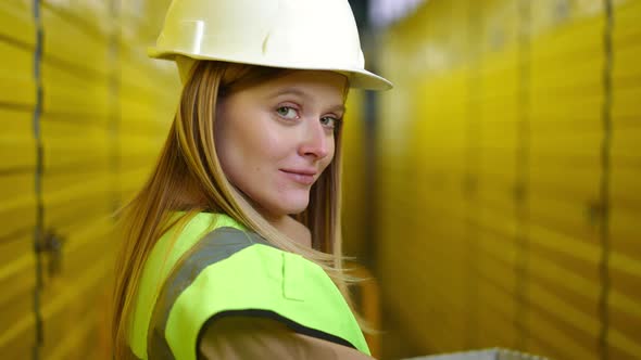 Charming Young Woman Turning to Camera Raising Eyebrows Flirting Standing in Warehouse