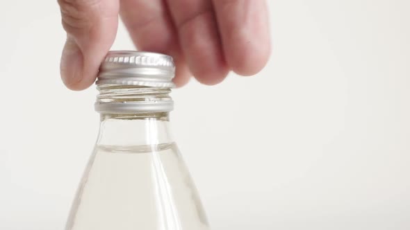 Unscrewing metal cap from top of a  bottle slow-mo footage