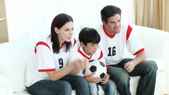 Family in Living Room Watching Sport on TV