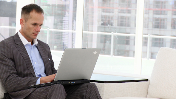 Handsome Business Man Working at a Laptop