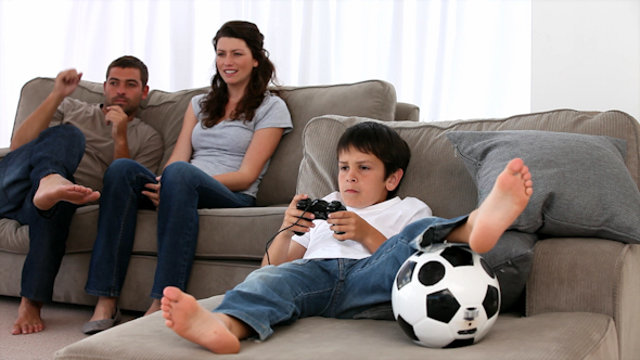 Cute Little Boy Playing Video Games and Parents Enjoying Watching