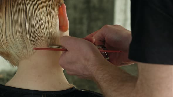 Hairdresser Trimming Blond Hair with Scissors