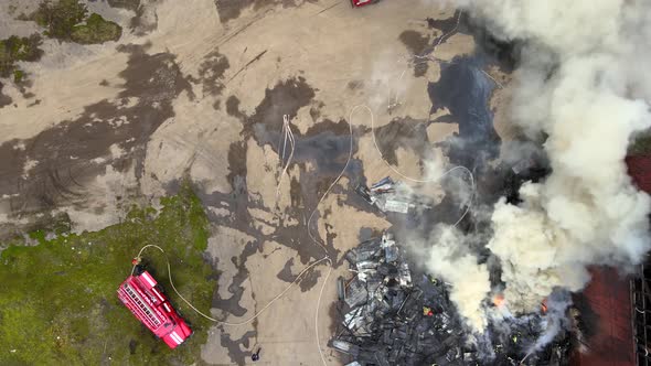 Aerial View of Firefighters Extinguishing Fire in Industrial Area