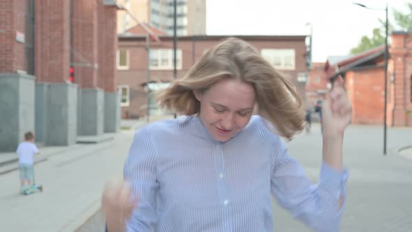 Woman Dancing in Joy While Walking in Street