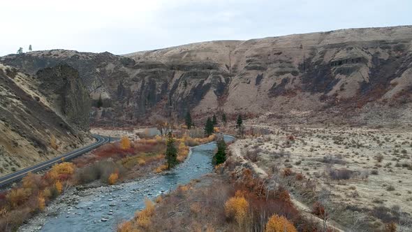 Ariel drone footage of a rugged river valley in fall.