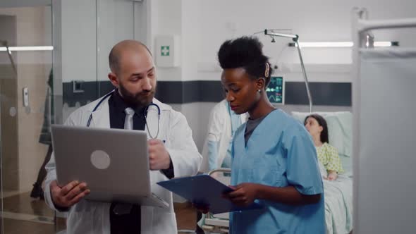 African Nurse and Surgeon Doctor in Medical Uniform Analyzing Illness Symptom