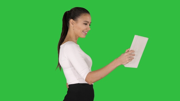 Happy woman making a video call with tablet on a Green